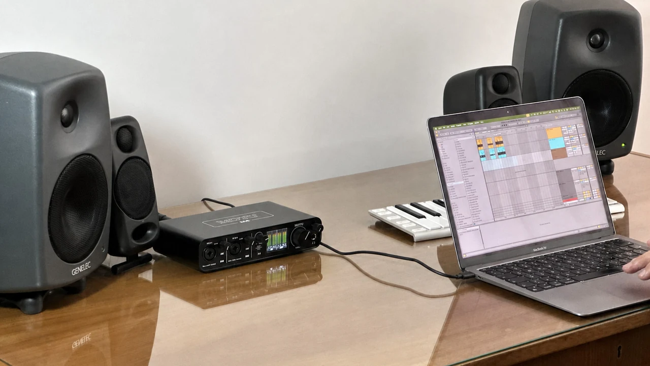 Studio photo of a MOTU M4 beside a MacBook Air