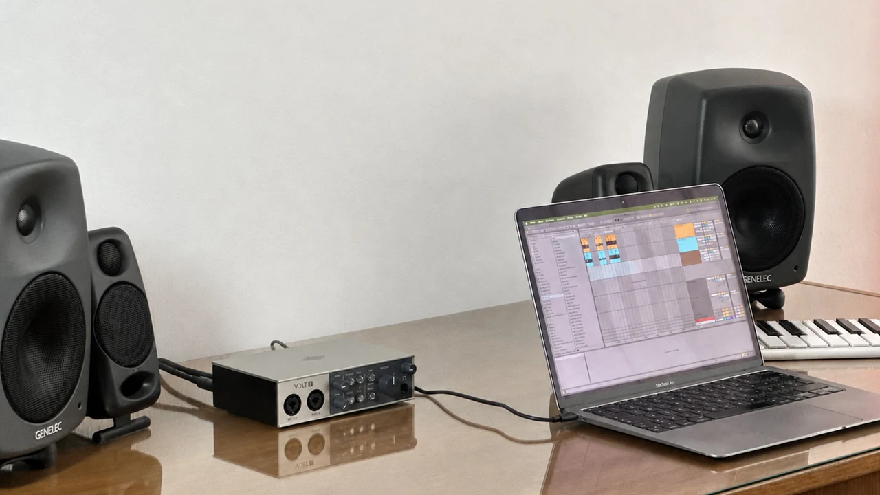 Studio photo of a Universal Audio Volt 2 beside a MacBook Air